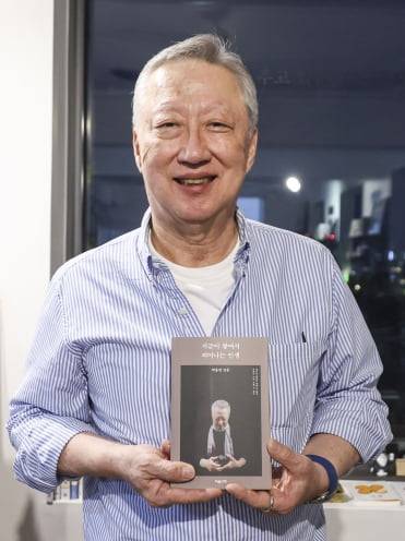 박용만 전 대한상공회의소 회장이 그의 두 번째 저서 <지금이 쌓여서 피어나는 인생>을 출간했다. 지난 3일 북콘서트에서 박 전 회장이 책을 들어보이고 있다.   임형택 기자