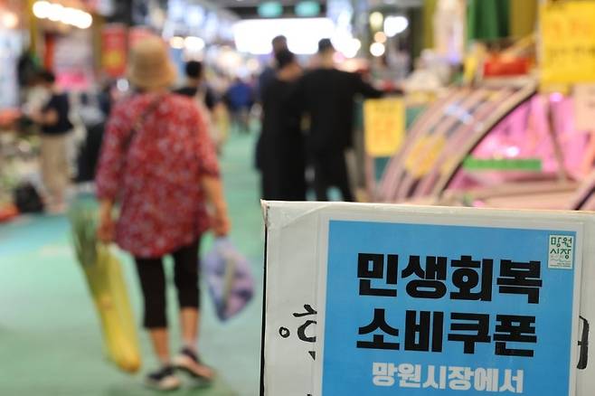 지난달 26일 서울 마포구 망원시장 매장에 소비쿠폰 안내문이 붙어 있다. 연합뉴스