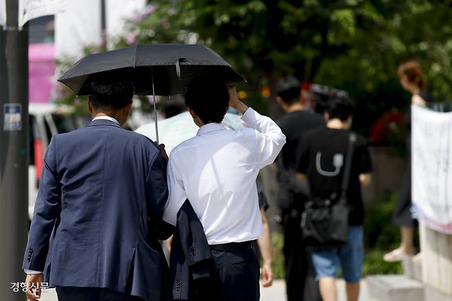 지난 7월24일 서울 도심에서 시민들이 양산을 쓴 채 걸어가고 있다. 문재원 기자