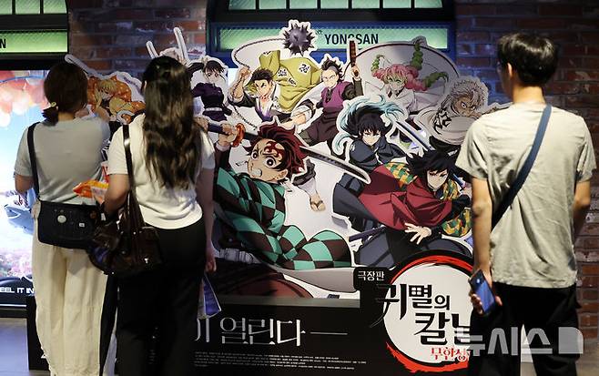 [서울=뉴시스] 조성우 기자 = 일본 애니메이션 영화 '극장판 귀멸의 칼날:무한성편'이 개봉 10일 만에 300만 관객을 넘긴 가운데 31일 서울 시내의 한 영화관에 시민들이 '귀멸의 칼날' 홍보물을 살펴보고 있다. 영화관입장권 통합전산망과 배급사 CJ ENM에 따르면, 지난 22일 개봉한 '극장판 귀멸의 칼날: 무한성편'은 이날 0시 기준 누적 301만2116명 관객을 기록했다. 2025.08.31. xconfind@newsis.com