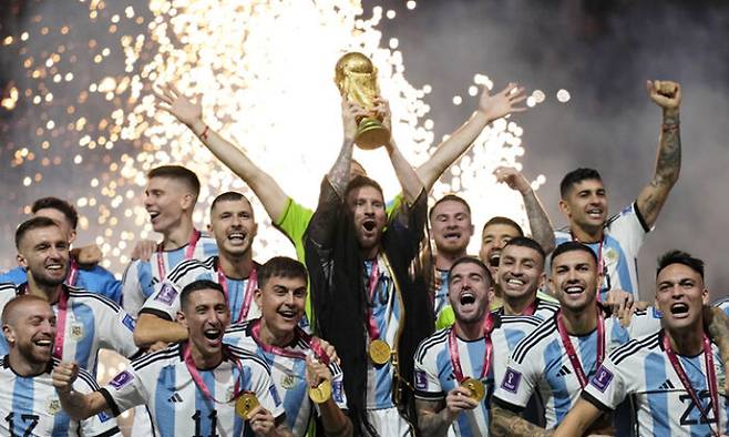 리오넬 메시(사진 가운데)와 아르헨티나 축구대표팀 선수들이 지난 2022년 12월 19일 카타르 루사일 스타디움에서 열린 2022 카타르 월드컵 결승전에서 프랑스를 꺾고 우승을 차지한 뒤 월드컵 트로피를 들고 환호하고 있다. 연합뉴스