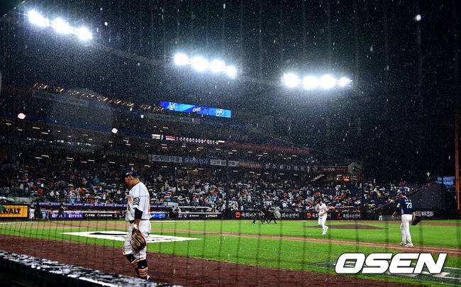 괴팍스러운 늦여름 소나기에 우천 중단으로 철수하는 선수들.