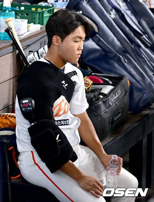 정우주가 연장 10회초 투구 중 우천 중단 된 가운데 어깨를 달구며 더그아웃에서 대기하고 있다.