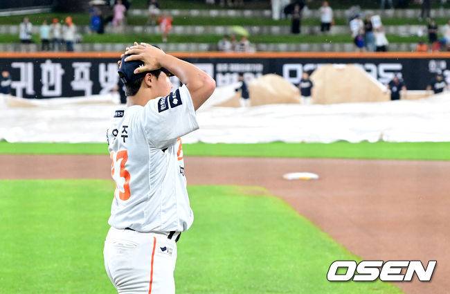 모자를 고쳐쓰며 웜업에 나서는 정우주.