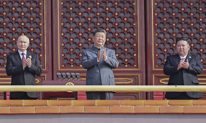 시진핑 중국 국가주석(가운데), 김정은 북한 국무위원장(오른쪽), 블라디미르 푸틴 러시아 대통령이 3일 베이징 톈안먼 망루에 나란히 올라 ‘중국인민 항일전쟁 및 세계 반파시스트 전쟁승리 80주년’ 기념 대규모 열병식을 지켜보며 박수를 치고 있다. 신화연합뉴스