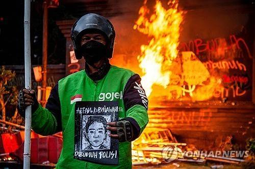 숨진 배달기사 초상화 든 동료 [AFP 연합뉴스. 재판매 및 DB 금지]