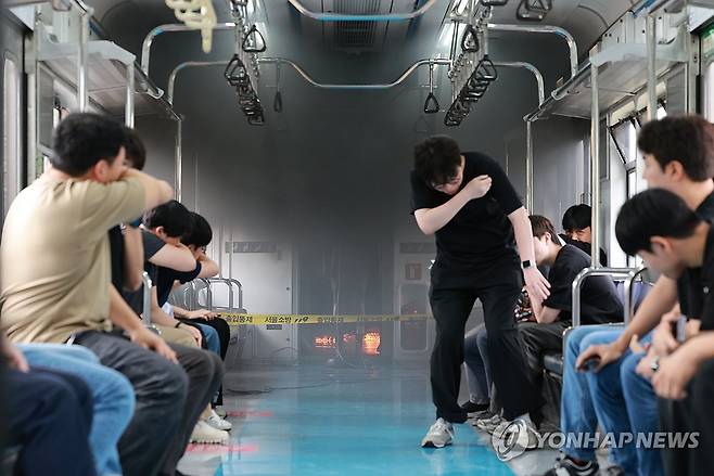 지축차량기지에서 열린 전동차 화재 시연 (고양=연합뉴스) 신현우 기자 = 4일 경기도 고양시 지축차량기지에서 전동차 화재 시연이 열린 가운데 불이 난 전동차 객실에서 승객을 가정한 서울교통공사 직원들이 대피하고 있다. 2025.9.4 nowwego@yna.co.kr