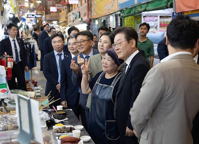 이재명 대통령이 5일 인천 용현시장을 방문해 민생회복 소비쿠폰 민심 청취 등을 하며 상인들과 기념촬영을 하고 있다. 대통령실 제공