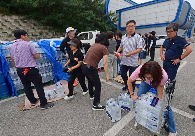 5일 강원 강릉시 강남동 강남축구공원에서 시민들이 생수를 받아 가고 있다. 강릉시는 수돗물 사용량을 조금이라도 줄이기 위해 전날부터 1인당 6일 치 생수 12L를 나눠 주고 있다. 강릉=연합뉴스
