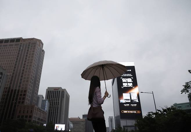 비가 내리는 4일 오전 광화문네거리를 지나는 시민들이 우산을 쓰고 걸어가고 있다. 연합뉴스