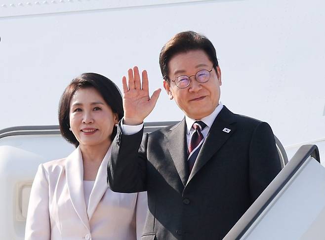 한일 정상회담을 마친 이재명 대통령과 부인 김혜경 여사가 지난달 24일 일본 도쿄 하네다공항에서 도널드 트럼프 미국 대통령과의 한미 정상회담을 위해 워싱턴DC로 향하며 공군1호기에 올라 인사하고 있다. 연합뉴스