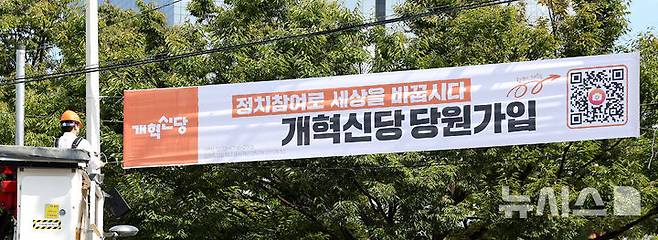 [대구=뉴시스] 이무열 기자 = 이준석 개혁신당 대표가 5일 대구 북구 경북대학교 북문 앞에서 정당 가입 독려 현수막을 직접 게첩하고 있다. 2025.09.05. lmy@newsis.com