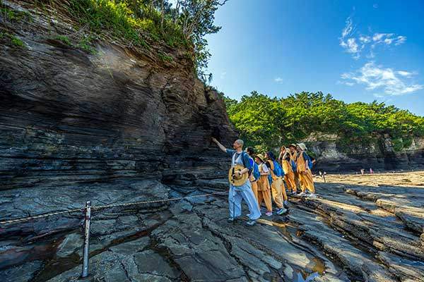 켜켜이 쌓인 채석강 절벽 지층을 관찰하고 있는 진각 스님과 참가자들.