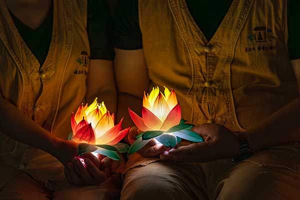 참가자들이 직접 만든 연등을 소중하게 품고 불빛을 바라보고 있다.
