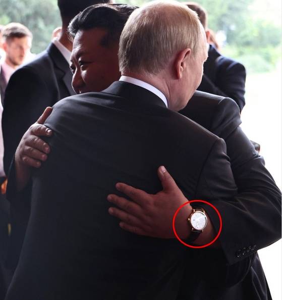 블라디미르 푸틴 러시아 대통령과 껴안는 김정은 북한 국무위원장. 김 위원장은 이날 스위스 명품 시계인 IWC (빨간 원)를 착용했다. AP 연합뉴스