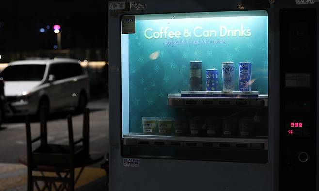 커피 자판기가 밤 어둠 속에서도 빛을 내고 있다. 여전히 작동 중이다.
