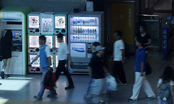 서울 용산역을 찾은 시민들이 자판기 옆을 지나고 있다.