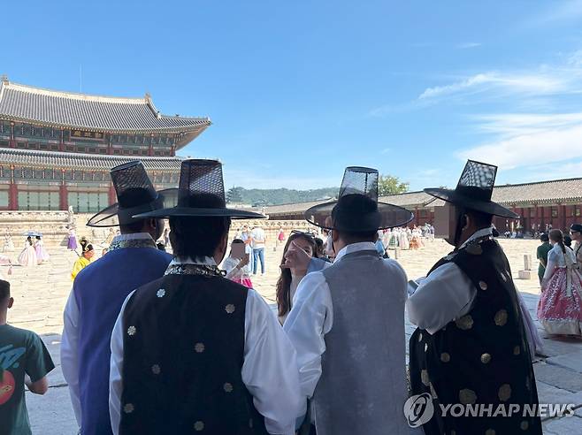 갓 쓰고 가이드 설명 듣고 있는 관광객들 (서울=연합뉴스) 최혜정 인턴기자 = 지난 3일 경복궁에서 갓을 쓴 외국인 관광객들이 가이드 설명을 듣고 있다. 2025.9.6