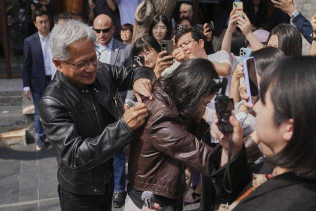 젠슨황 엔비디아 최고경영자(CEO)가 지난 7월6일 베이징에서 열린 ‘제3회 중국 국제공급망촉진박람회’에 참석한 뒤 만다린 오리엔탈 첸먼에서 기자회견 도중 한 기자의 가죽 재킷에 사인을 하고 있다. ⓒ AP/연합뉴스