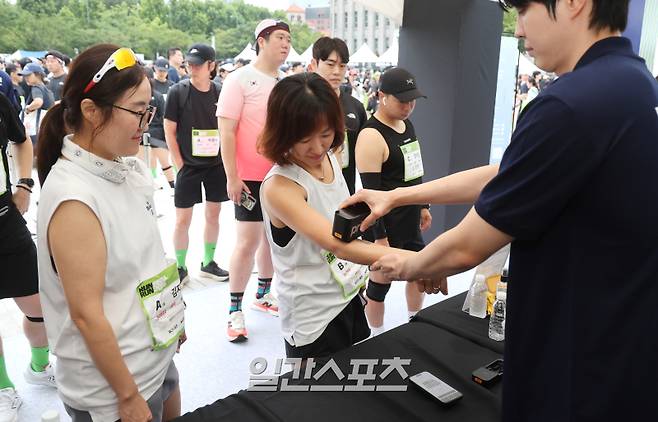 '런서울런 2025'의 경기 시작 전 러너들이 KGM 부스에서 프린팅 타투존에 참여하고 있는 모습. 김민규 기자&nbsp;