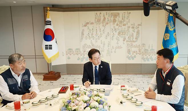 이재명 대통령이 4일 서울 용산 대통령실 청사에서 양대노총 위원장과의 오찬 간담회를 하며 김동명 한국노총 위원장, 양경수 민주노총 위원장의 발언을 경청하고 있다. [연합]