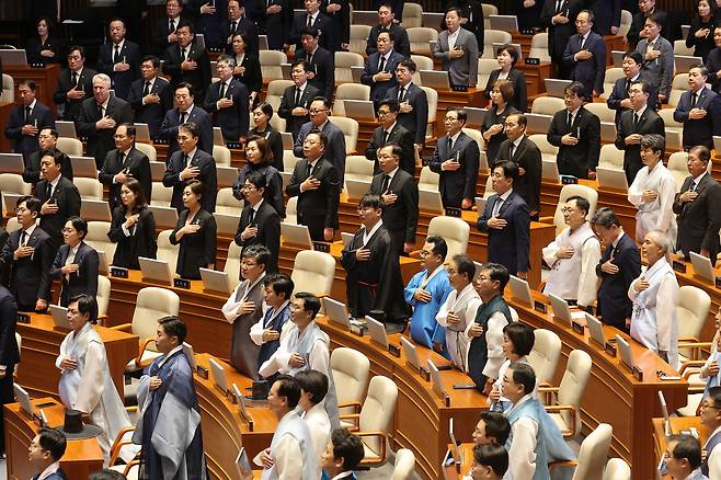 지난 1일 서울 여의도 국회에서 열린 정기국회 개회식에서 한복과 상복을 입은 여야 의원들이 국기에 대한 경례를 하고 있다. [연합]
