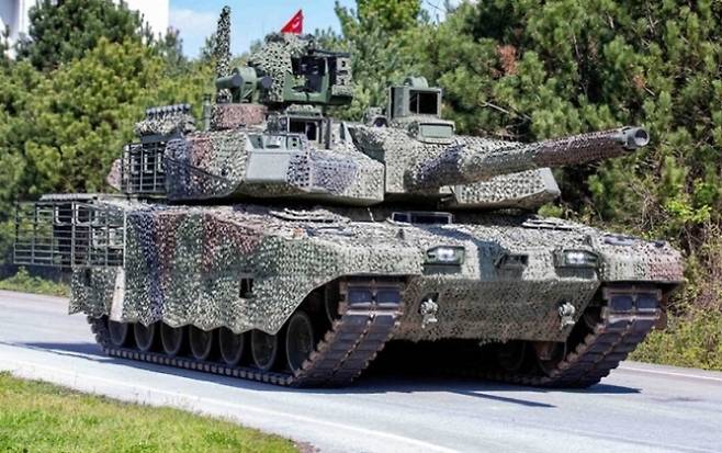 튀르키예 알타이 전차 시제차량이 도로 주행을 실시하는 모습. 차체 위에는 터키 국기가 걸려 있다. 출처=밀리터리 워치 매거진