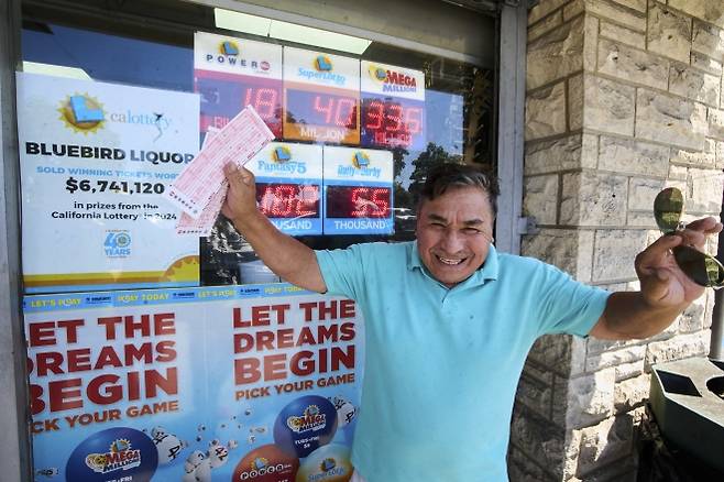 “초대박 꿈을 꿔볼까” - 5일(현지시간) 미 캘리포니아주 호손의 블루버드 주류 판매점에서 페루 출신 남성이 파워볼 복권을 구매한 후 즐거워하고 있다. 지난 3일 파워볼 추첨에서 1등 당첨자가 나오지 않아 누적 당첨금이 18억 달러(약 2조5천억원)로 늘어났다. 2025.09.06. AP 뉴시스