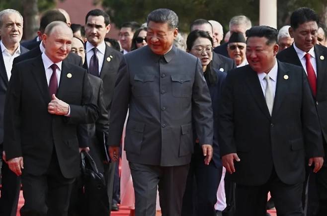 지난 3일 중국 베이징에서 열린 전승절 80주년 열병식 행사에서 시진핑(가운데) 중국 국가주석이 블라디미르 푸틴(왼쪽) 러시아 대통령, 김정은(오른쪽) 북한 국무위원장 등 각국 정상들을 이끌고 있다. 베이징 AP 연합뉴스