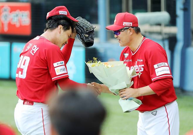 SSG 랜더스 김광현(왼쪽)이 7일 서울 잠실야구장에서 열린 2025 신한 SOL Bank KBO리그 LG 트윈스와의 팀 간 16차전에 선발등판, KBO리그 역대 세 번째 2000탈삼진을 달성한 뒤 이숭용 감독에게 축하 받는 모습. 사진 SSG 랜더스