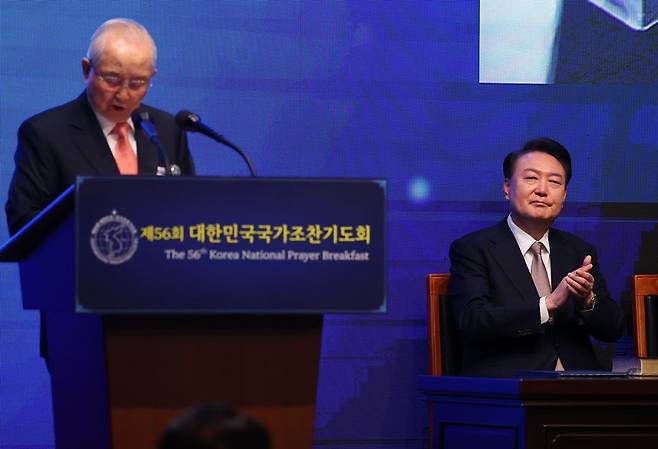 김장환 목사(극동방송 이사장)가 지난해 11월 22일 서울 중구 신라호텔에서 열린 제56회 국가조찬기도회에서 설교를 하고 있다. 윤석열 전 대통령이 설교를 듣다 박수를 치고 있다. 사진=뉴시스
