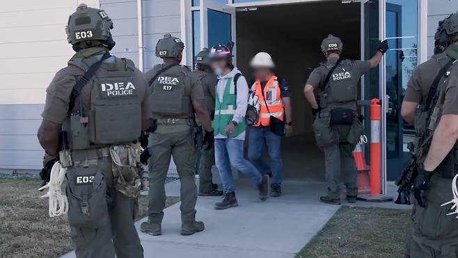 4일(현지 시각)  미이민세관단속국이 전격 단속을 실시한 미국 조지아주 현대차그룹-LG에너지솔루션 합작 배터리 공장 건설 현장에서 무장한 마약단속국(DEA) 요원들이 지켜보는 가운데 공장 직원들이 작업을 중지하고 밖으로 나오고 있다./ICE홈페이지