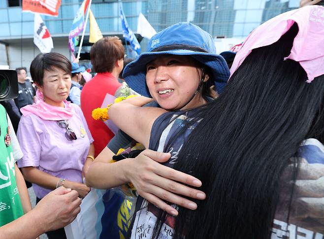 고용승계를 요구하며 600일간 고공농성을 이어갔던 박정혜 한국옵티칼하이테크 수석부지회장이 2025년 7월29일 경북 구미시 한국옵티컬하이테크 공장 옥상에서 농성을 마치고 땅으로 내려와 지인들과 포옹하고 있다. 한겨레 김태형 기자 xogud555@hani.co.kr