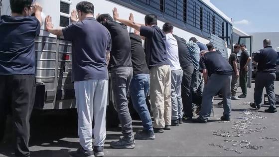 미국 이민세관단속국(ICE)과 국토안보수사국(HSI) 등 소속 요원들이 4일(현지시간) 현대자동차와 LG에너지솔루션이 조지아주 서베나에 공동으로 건설중인 배터리 공장에서 불법체류자 단속을 벌여 475명을 단속했다. 이 중 300여명이 한국인으로 파악된다. 사진은 이날 단속 요원들이 현장 직원들의 손목과 다리를 수갑과 쇠사슬로 묶고 있는 모습. [사진 ICE 동영상 캡처]