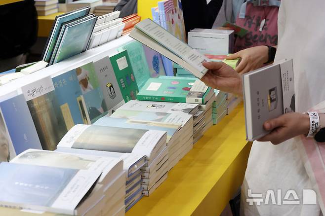 [서울=뉴시스] 박진희 기자 = 세계인의 책 잔치 '2025 서울국제도서전'이 열린 18일 서울 강남구 코엑스 행사장을 찾은 관람객들이 전시 도서를 살펴보고 있다. 올해 도서전에는 한국을 포함해 17개국의 530여 개 출판사와 출판 관련 단체 등이 참가한다. 2025.06.18. pak7130@newsis.com