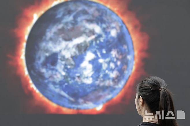 [서울=뉴시스] 지난해 9월 19일 서울 서대문구 유플렉스 앞 스타광장에서 그린피스 서울사무소가 GDP 맹신의 부작용을 알리는 퍼포먼스를 위해 설치한 전광판에 뜨거운 지구를 묘사한 화면이 나오고 있다. 2024.09.19. photocdj@newsis.com