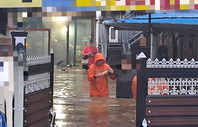 전북지역에 집중호우가 쏟아진 7일 물에 잠긴 전주 완산구 색장동의 한 주택에서 소방대원이 주민을 구조하고 있다. 전주 연합뉴스