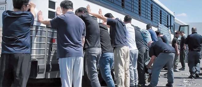 지난 4일 미국 이민 당국이 조지아주의 현대차·LG에너지솔루션 공장을 단속할 당시 한국인 등 현장 직원들이 길게 늘어서 차례로 몸수색을 당하고 있다. /이민세관단속국