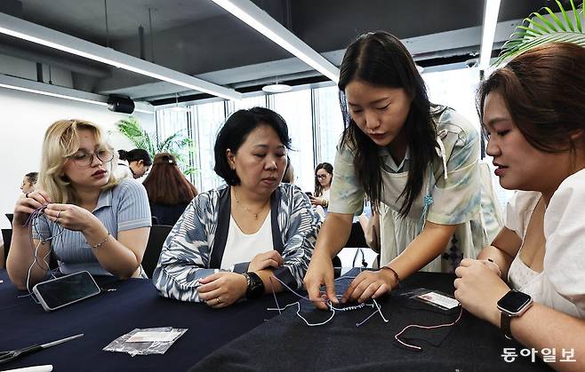 서울 종로구 서울관광재단에서 외국인 관광객들이 전통 매듭 공예 프로그램에 참여해 팔찌를 만들고 있다. 
양회성 기자 yohan@donga.com