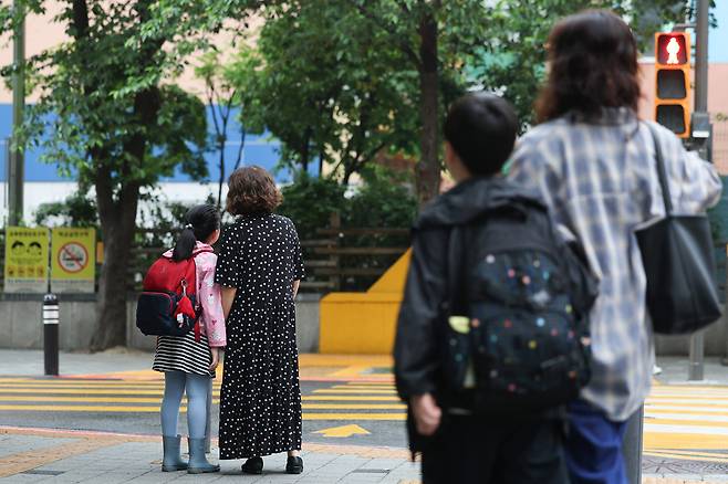 부모가 자녀들을 학교에 데려다주고 있다. 정부는 내년 중소기업 근로자를 대상으로 ‘육아기 10시 출근제’를 전국에서 시행할 예정이다. 뉴스1