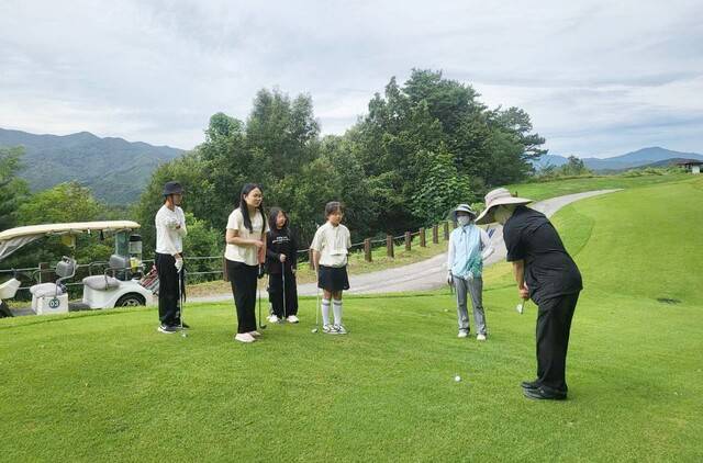 골프연습장에서 기초 레슨을 받은 뒤 실제 코스 잔디 위에서 샷을 해보고 있다. /사진제공=장수골프리조트