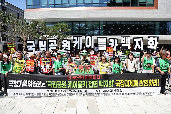 지난 7월10일 서울 국정기획위원회 앞에서 열린 ‘국립공원 케이블카 전면 백지화’ 요구 기자회견에서 설악산국립공원지키기국민행동 등 참석자들이 관련 구호를 외치고 있다. 연합뉴스