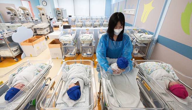 A woman holds a baby in a nursery at a hospital in Ilsan on Aug 27. [NEWS1]