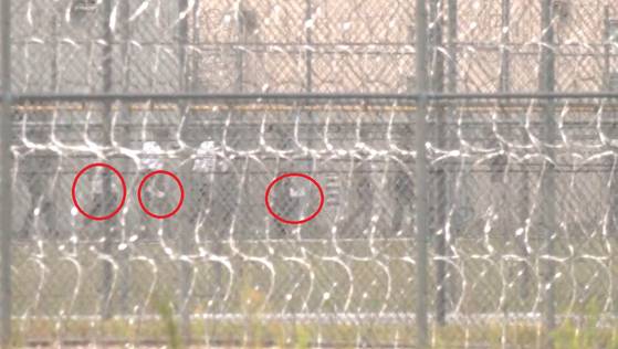 Workers from the LG Energy Solution-Hyundai Motor battery plant construction site in Georgia stand in line in blue uniforms at the Folkston detention center on Aug. 8, with documents in hand. [KANG TAE-HWA]