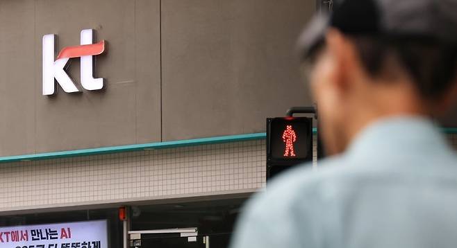 한 시민이 서울 KT 판매점 앞을 지나고 있다. [연합]
