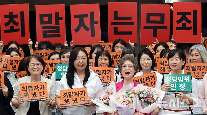 [부산=뉴시스] 하경민 기자 = 61년 전 성폭행에 저항하는 과정에서 가해자의 혀를 깨물어 1.5㎝가량 절단하는 상해를 입혔다는 이유로 가해자보다 더 중한 형을 선고받았던 최말자(79)씨가 재심에서 무죄를 선고받았다.  10일 부산 연제구 부산지방법원 앞에서 최씨가 여성단체 회원들과 함께 무죄 선고에 기뻐하고 있다. 2025.09.10. yulnetphoto@newsis.com