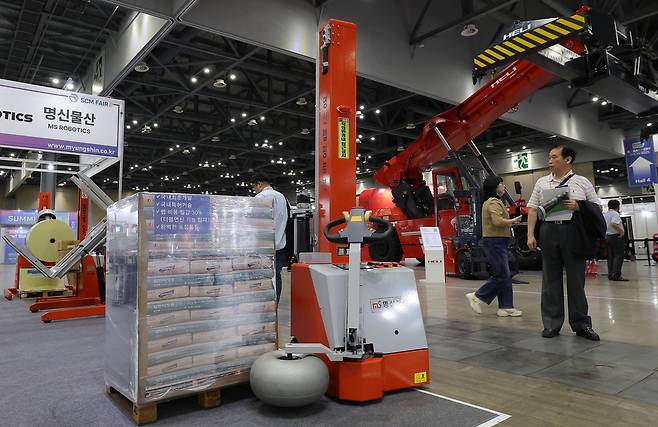 10일 경기 고양시 킨텍스에서 열린 제5회 국제 운송·공급망 관리 산업전(SCM FAIR 2025)을 찾은 관람객들이 자동랩핑 로봇을 살펴보고 있다.
