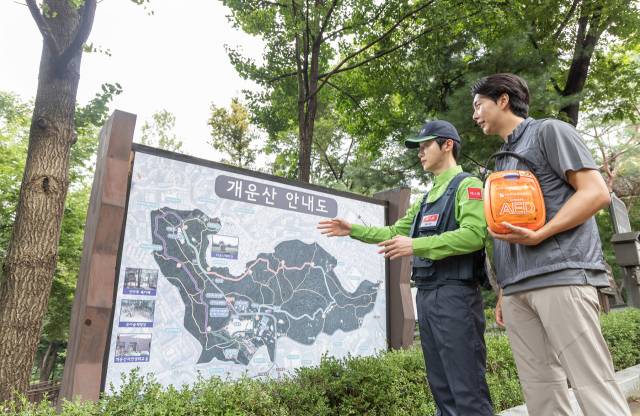 에스원 직원이 등산객에게 등산로에 있는 자동심장충격기(AED) 위치를 알려주고 있다. 사진 제공=에스원