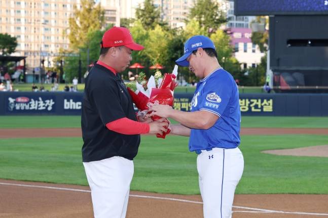 삼성 오승환(오른쪽)이 10일 광주 KIA-삼성전을 앞두고 열린 자신의 은퇴투어 행사에서 KIA 이범호 감독에게 꽃다발을 받고 있다. /사진=KIA 타이거즈 제공