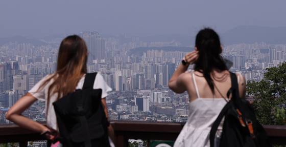 서울 남산을 찾은 관광객이 도심 아파트 단지를 바라보고 있다. [뉴스1]
